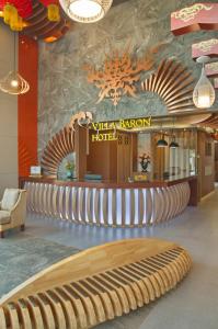 a hotel lobby with a bench and a hotel sign at Villa Baron SHA PLUS in Nonthaburi