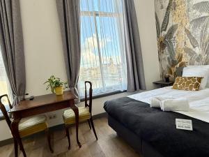 a bedroom with a bed and a desk and a window at Boutique Hotel Joure - centrum & haven in Joure