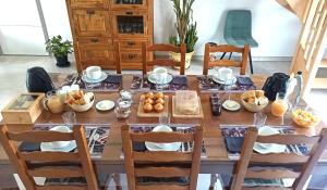 a dining room table with breakfast foods on it at Chambres d'hôtes Le puits du Bréneau in Orbigny