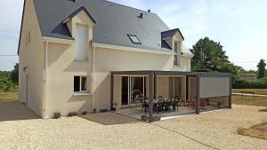 a house with a deck with a dog on it at Chambres d'hôtes Le puits du Bréneau in Orbigny