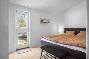 a bedroom with a large bed and a window at BL1163-Blokhus-Raappenmark-2 in Blokhus +23 photos