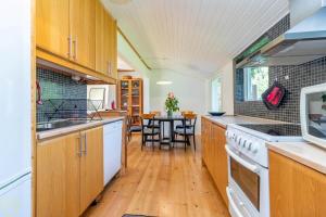 a kitchen with wooden cabinets and a dining room with a table at VGO922-Grabo-Strandkullen-22 in Gråbo
