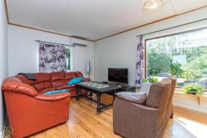 a living room with a leather couch and a table at VGO922-Grabo-Strandkullen-22 in Gråbo