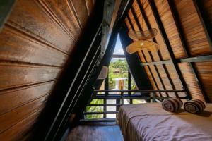 a bedroom with a bed in a room with a window at Brisa Lofts Uluwatu in Uluwatu +5 photos