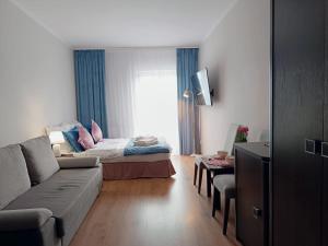 a living room with a couch and a bed at JULA Pokoje Blisko Plaży, Dąbki in Dąbki
