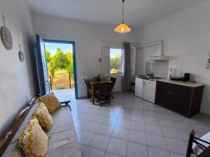 ein Wohnzimmer mit Sofa und eine Küche mit Tisch in der Unterkunft Villa Orizontes in Spetses