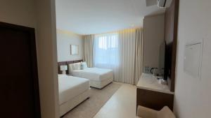 a hotel room with two beds and a window at Hatta Residence in Hatta