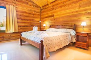 a bedroom with two beds in a log cabin at casas del milagro in Villa General Belgrano