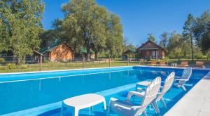 a swimming pool with chairs and a house at casas del milagro in Villa General Belgrano