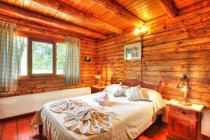 a bedroom with a bed in a log cabin at casas del milagro in Villa General Belgrano