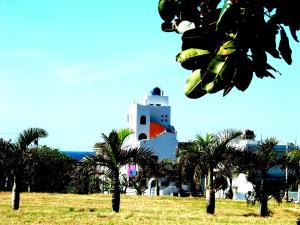 a building with palm trees in front of it at Little Path Kenting in Eluan