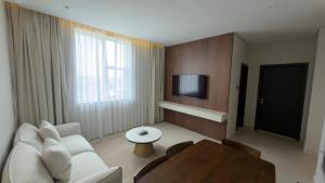 a living room with a white couch and a tv at Hatta Residence in Hatta +8 photos