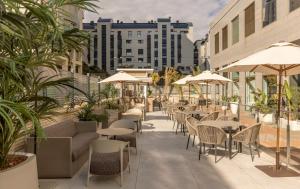 an outdoor patio with tables and chairs and umbrellas at Ilunion Valencia 4 in Valencia