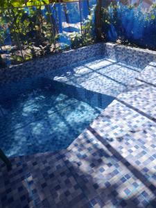 a swimming pool with a tiled floor and the sun shining at Aguas de Alter in Santarém