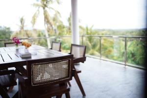 a table and chairs on a balcony with a view at Nomad's Peak Hiriketiya in Dickwella