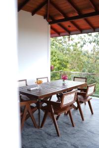 a wooden table and chairs on a patio at Nomad's Peak Hiriketiya in Dickwella +44 photos