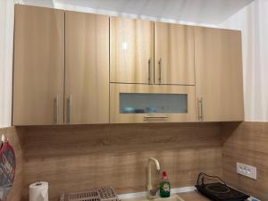 a kitchen with wooden cabinets and a sink at Apartman Iva in Soko Banja +56 photos