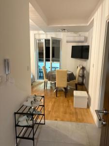 a living room with a table and chairs and a television at Apartman Iva in Soko Banja