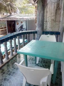 a green table and white chairs on a balcony at Old Castle in Anda