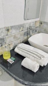 a bathroom with a sink and towels on a table at Hotel Aman in Patna
