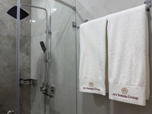 a shower with white towels on a shower curtain at ART REGENCY Premium Hotel in Tashkent +44 photos