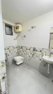 a bathroom with a toilet and a sink at Hotel Aman in Patna +10 photos