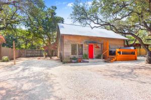 a small wooden house with a red door at Happy Hideaway in Wimberley +26 photos
