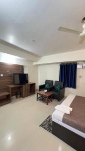 a room with a bed and a couch and a tv at Hotel Aman in Patna