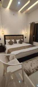 a bedroom with a large bed and a chair at Himalaya View Resort in Barkot