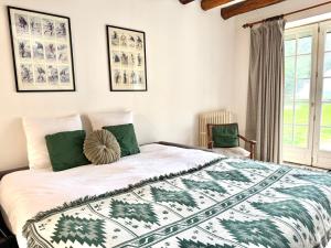 a bedroom with a bed with a green and white blanket at Le duplex - Cosy & Pratique in Gastins