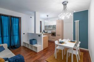 a living room with a white table and a kitchen at La Casetta di Gio in Busnago