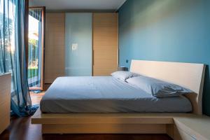 a bedroom with a large bed with a blue wall at La Casetta di Gio in Busnago