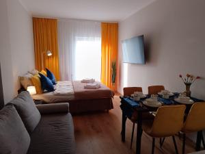 a living room with a bed and a table with chairs at JULA Pokoje Blisko Plaży, Dąbki in Dąbki