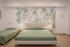 a bedroom with two beds and a floral wall at Lungomare 70 in Marzocca di Senigallia
