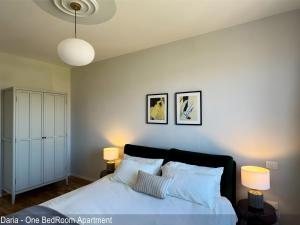 a bedroom with a white bed with two lamps at Saverio & Daria Aprtements by Mamo Florence in Florence +13 photos