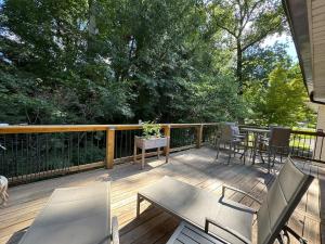 a wooden deck with chairs and a table on it at Super Comfy 3 BR Home Sleeps 8 in Doraville