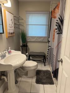 a bathroom with a white toilet and a sink at Super Comfy 3 BR Home Sleeps 8 in Doraville +4 photos