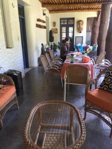 a woman sitting at a table in a room with chairs at Villa Rossy in Samaipata