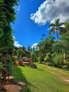 a yard with green grass and trees and a blue sky at Villa Rossy in Samaipata
