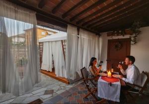 a man and woman sitting at a table with a candle at La Suite Toscana in Certaldo