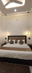 a large bed in a bedroom with two lights at Himalaya View Resort in Barkot +29 photos