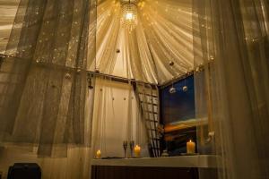 a room with a window with two candles and a chandelier at La Suite Toscana in Certaldo