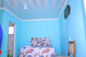 a blue room with a bed and a tv at Equatorial Guest House in Rustenburg