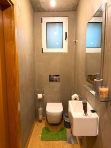 a bathroom with a white toilet and a sink at Porto Santo Balcony View House in Porto Santo