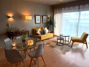 a living room with a table and a yellow couch at Porto Santo Balcony View House in Porto Santo