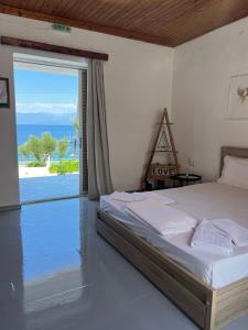 ein Schlafzimmer mit einem Bett und Meerblick in der Unterkunft ARTAKi R APARTMENTS in Koroni
