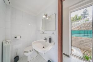a bathroom with a sink and a toilet and a window at Sea Dream - Vista Mare - Giardino - Box Privato in Bergeggi +31 photos