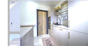 a kitchen with white cabinets and a wooden door at Villa 2 chambres in Trooz +6 photos