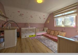 a childs room with a couch and a crib at Villa 2 chambres in Trooz