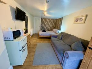a living room with a couch and a bed at Travellers Rest Motel in Ingoldmells